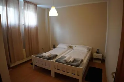 a bedroom with a bed with white sheets and pillows at Apartmani Kula - Apartman 2 in Novi Banovci