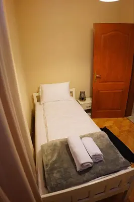 a small room with a bed with two towels on it at Apartmani Kula - Apartman 2 in Novi Banovci