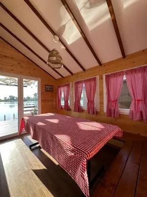 a bedroom with a bed in a room with windows at Splav na Savi in Ostružnica