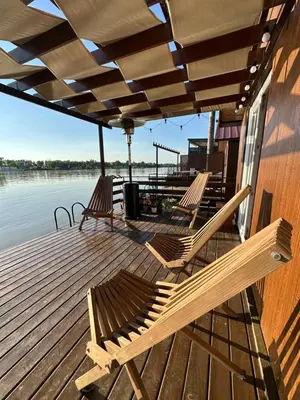 two benches sitting on a deck next to the water at Splav na Savi in Ostružnica