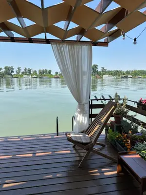 a deck with a chair and a view of the water at Splav na Savi in Ostružnica