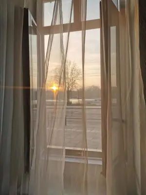 an open window with the sunset seen through it at - WHITE - white&black Apartmans-Free parking- in Belgrade
