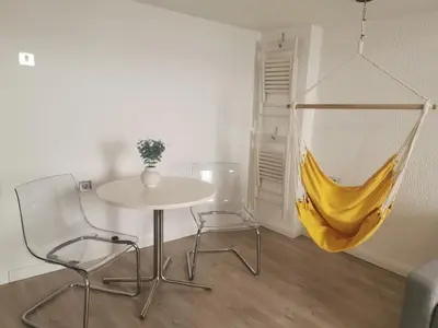 a table and two chairs and a yellow hammock in a room at - WHITE - white&black Apartmans-Free parking- in Belgrade