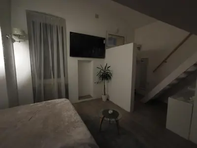 a living room with a couch and a tv on the wall at - WHITE - white&black Apartmans-Free parking- in Belgrade