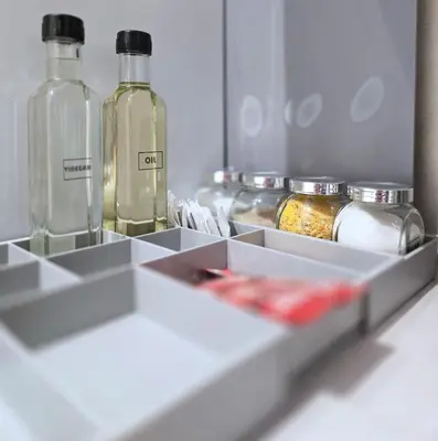 three glass bottles sitting on a shelf in a drawer at Boneca apartment in Belgrade