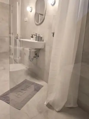 a white bathroom with a sink and a mirror at Boneca apartment in Belgrade