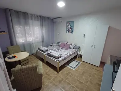 a bedroom with a bed and a table and chairs at Apartments DAJER in Arandjelovac