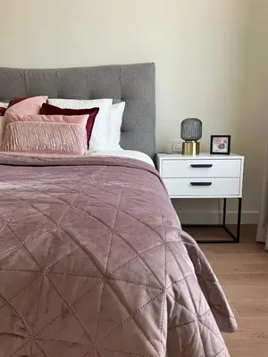 a bedroom with a bed and a white night stand at Waterfront Nights in Belgrade