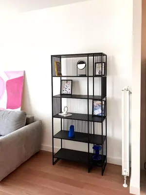 a black book shelf in a living room with a couch at Waterfront Nights in Belgrade