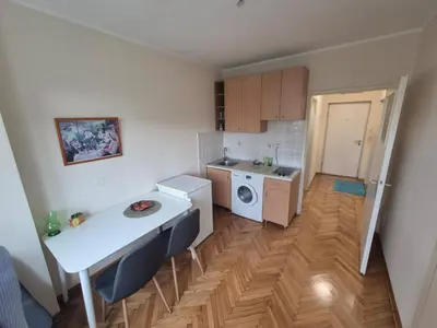 a small kitchen with a table and a laundry room at Sunny Lux Apartment Terazije in Belgrade
