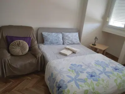 a small bedroom with a bed and a chair at Sunny Lux Apartment Terazije in Belgrade