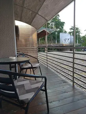 a train station with chairs and a table and train tracks at ParkSide Apartman in Arandjelovac