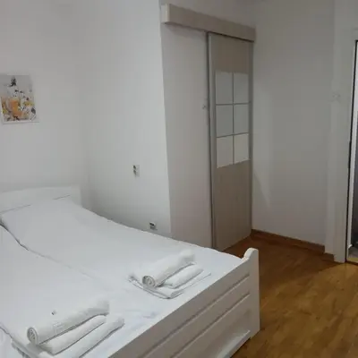 a white bed with two white towels on it at ParkSide Apartman in Arandjelovac