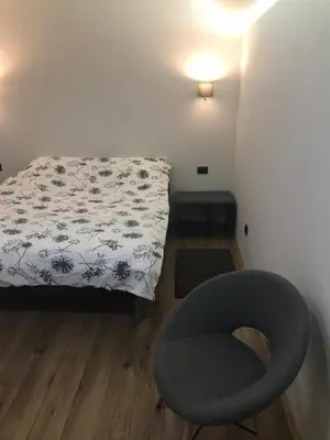 a bedroom with a bed and a chair and a lamp at Apartment Nevena 3 in Belgrade