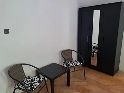 a room with two chairs and a table and a mirror at Quiet garden in Belgrade
