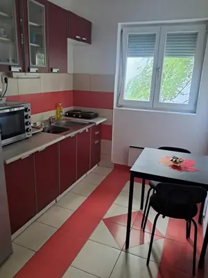 a kitchen with a table and a sink and a window at Quiet garden in Belgrade