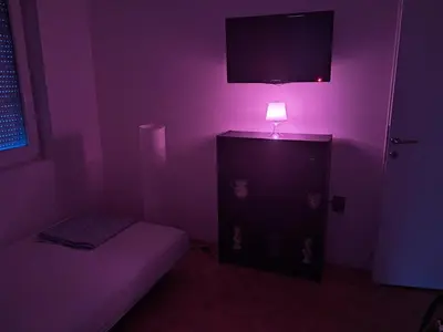 a purple room with a bed and a lamp at Quiet garden in Belgrade