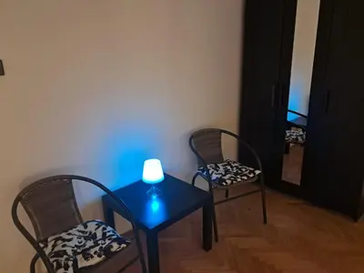 a room with two chairs and a table with a lamp on it at Quiet garden in Belgrade