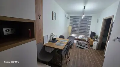 a dining room with a table and chairs in a room at Apartman Mima in Inđija