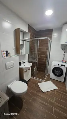 a bathroom with a toilet a sink and a shower at Apartman Mima in Inđija