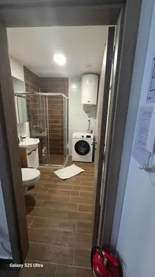 a bathroom with a toilet and a sink and a shower at Apartman Mima in Inđija