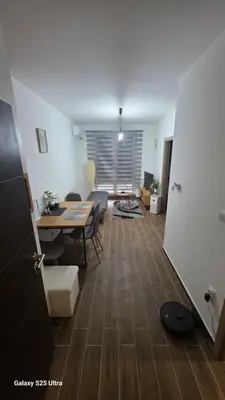 a living room with a table and chairs in a room at Apartman Mima in Inđija