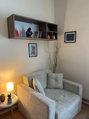 a living room with a couch and a chair at Guest House A'storia in Ruma