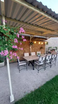 a table and chairs under a patio umbrella at Guest House A'storia in Ruma