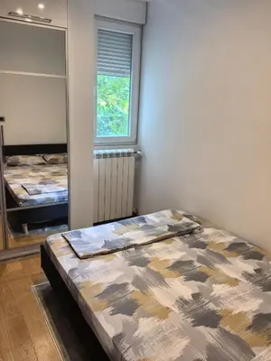 a bedroom with a bed in a room with a mirror at Kalemegdan park & Zoo - City center in Belgrade