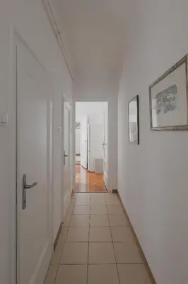a hallway with white walls and a tile floor at Radio Belgrade Apartment in Belgrade