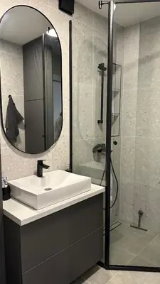 a bathroom with a sink and a shower with a mirror at District 21 in Belgrade