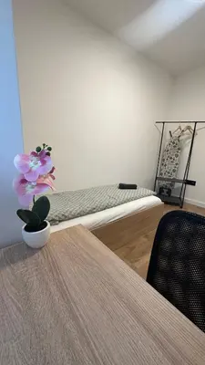 a room with a bed and a table with a flower at District 21 in Belgrade