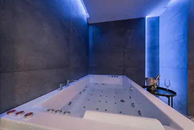 a large bath tub in a bathroom with blue lighting at Rei 2 in Belgrade