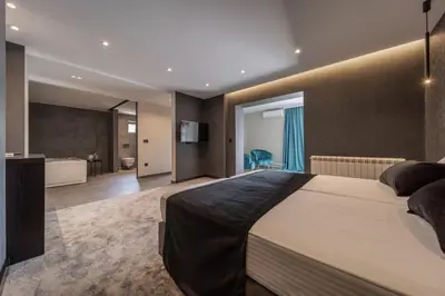 a bedroom with a large bed and a bathroom at Rei 2 in Belgrade