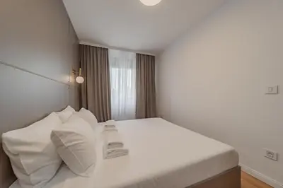 a bedroom with a bed with white sheets and pillows at Rei 2 in Belgrade