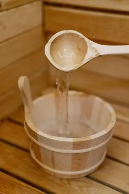 a wooden spoon pouring water into a bowl at Rei 2 in Belgrade