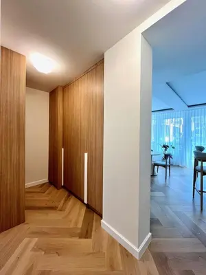 an empty living room with wooden cabinets and a table at Luxury apartment in the heart of Vračar in Belgrade