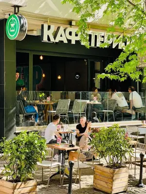 a group of people sitting at tables outside a restaurant at Luxury apartment in the heart of Vračar in Belgrade