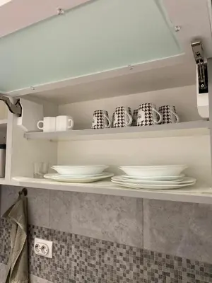 a shelf with plates and cups in a kitchen at Apartman Oaza in Smederevo