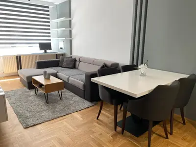 a living room with a couch and a table and chairs at Apartman Oaza in Smederevo