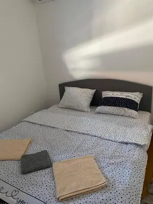 a bed with pillows and towels on top of it at Zmaj LUX in Mladenovac