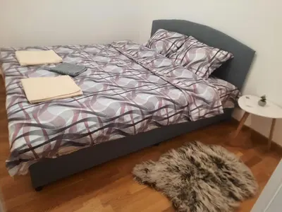 a bedroom with a bed with a black frame at Zmaj LUX in Mladenovac
