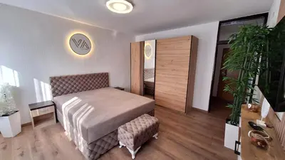 a bedroom with a bed and a chair at Valia apartments 2 in Belgrade