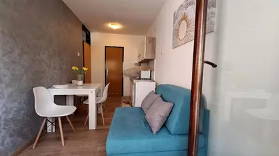 a living room with a blue chair and a table at Valia apartments 2 in Belgrade