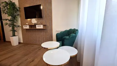 a living room with two tables and a couch and a tv at Valia apartments 2 in Belgrade