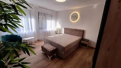 a bedroom with a bed and a chair in a room at Valia apartments 2 in Belgrade