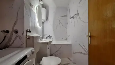 a white bathroom with a toilet and a sink at Valia apartments 2 in Belgrade