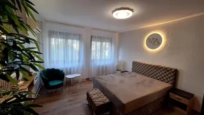 a bedroom with a bed and a chair and a window at Valia apartments 2 in Belgrade