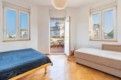 a bedroom with a bed and a couch and windows at The View That Never Gets Old - Kalemegdan in Belgrade