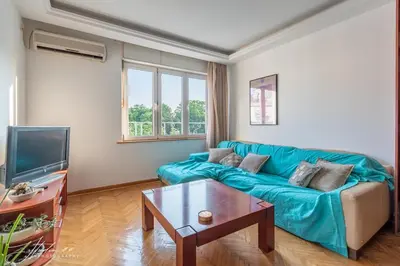 a living room with a blue couch and a table at The View That Never Gets Old - Kalemegdan in Belgrade